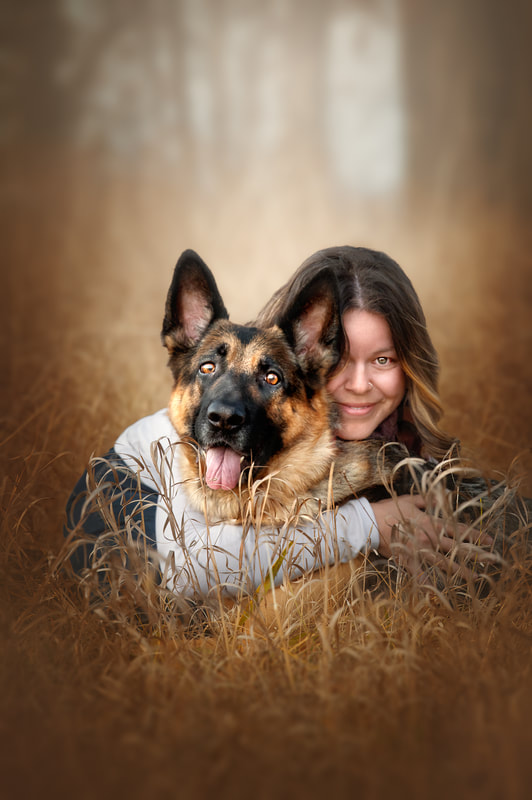 Woman with her German Shepherd Dog in golden field